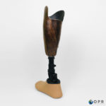 prothèse tibiale de jambe en carbone avec esthétique en bois des motifs u-exist realisé par les prothésistes en bretagne a rennes et en normandie a avranches et saint lo